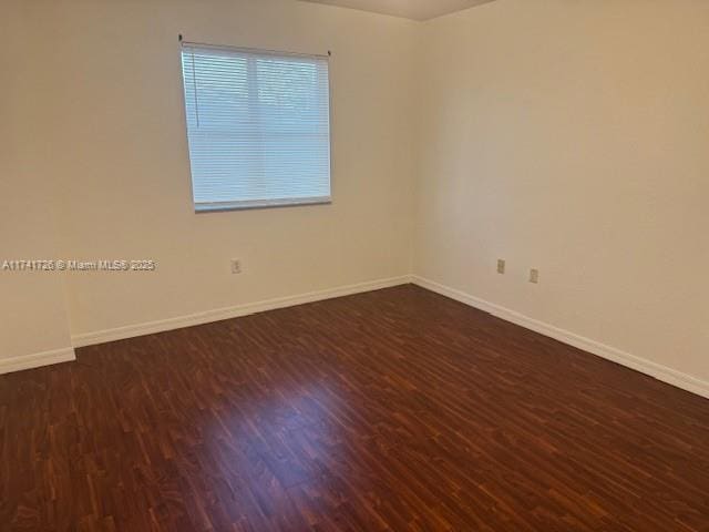 spare room with dark hardwood / wood-style floors