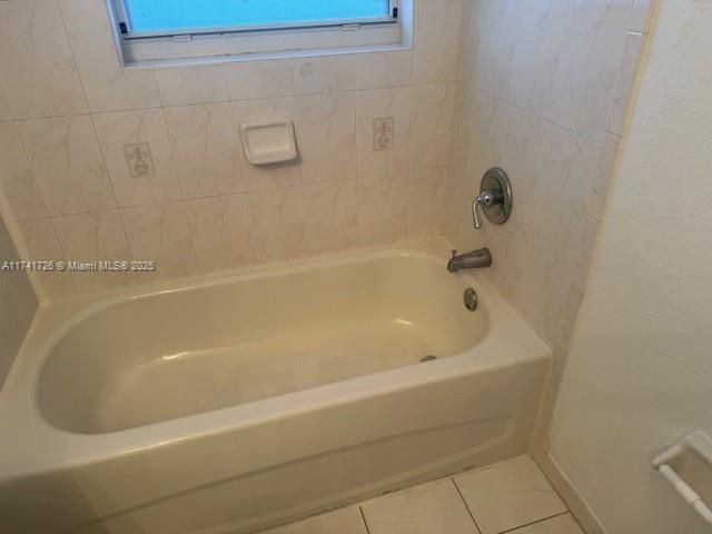 bathroom featuring tiled shower / bath and tile patterned floors