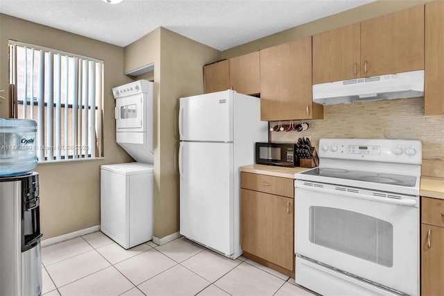 kitchen featuring stacked washer and dryer, white appliances, light tile patterned floors, and decorative backsplash