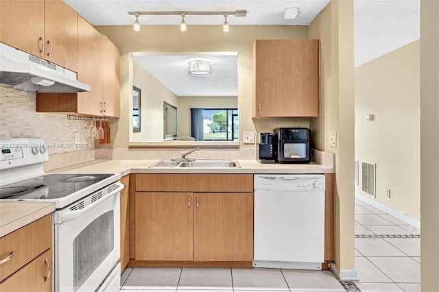 kitchen with white appliances, sink, a textured ceiling, and light tile patterned floors