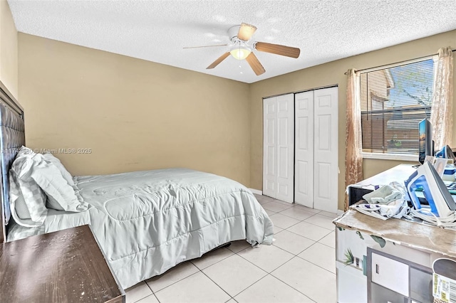 tiled bedroom with a textured ceiling, ceiling fan, and a closet