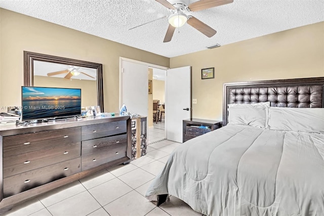 bedroom with ceiling fan, a textured ceiling, and light tile patterned floors