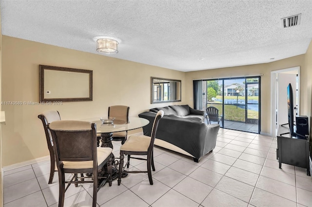 dining area featuring a textured ceiling and light tile patterned floors