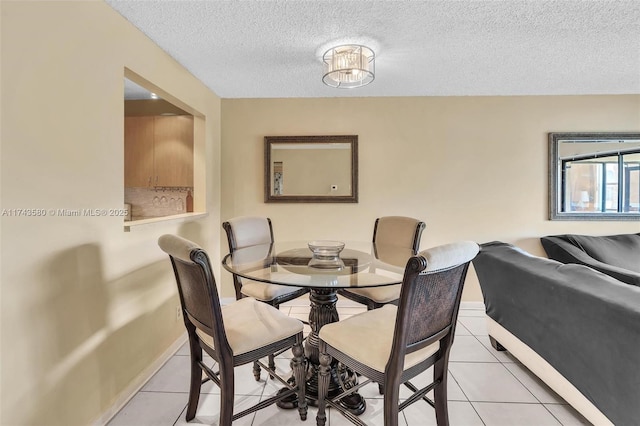 tiled dining space featuring a textured ceiling