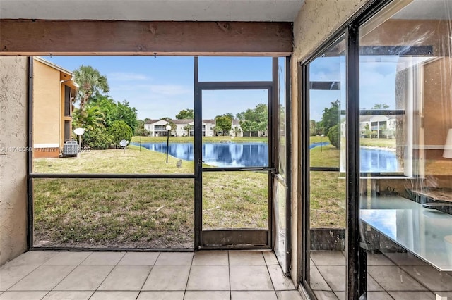 unfurnished sunroom with a water view