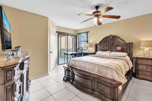 tiled bedroom with access to exterior, a textured ceiling, and ceiling fan