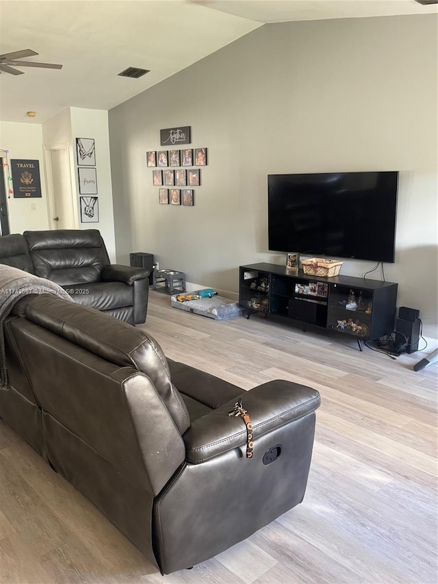 living room featuring ceiling fan, lofted ceiling, and light wood-type flooring