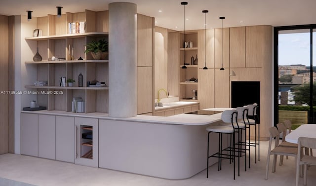 kitchen with built in shelves, a kitchen bar, sink, decorative light fixtures, and expansive windows