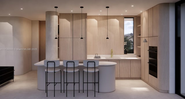 kitchen with hanging light fixtures, black double oven, a kitchen island, and light brown cabinets