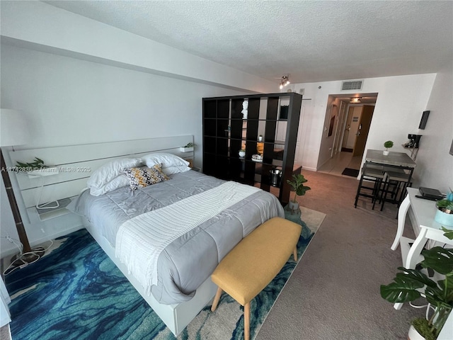 bedroom featuring carpet flooring and a textured ceiling