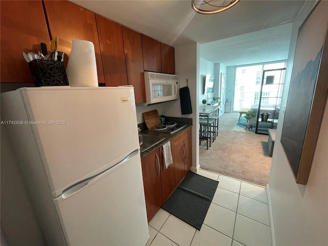 kitchen featuring sink, light carpet, and white appliances