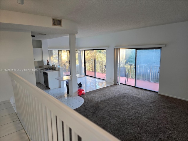 unfurnished living room featuring light carpet and a textured ceiling