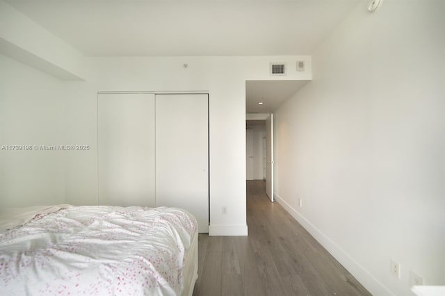 bedroom featuring dark hardwood / wood-style flooring and a closet