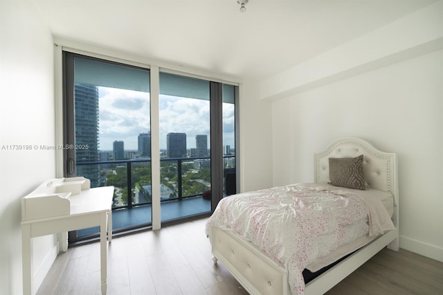 bedroom featuring floor to ceiling windows and light hardwood / wood-style floors