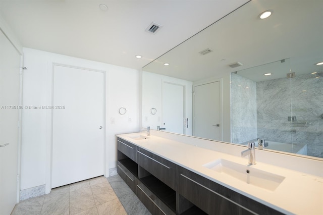 bathroom featuring tiled shower and vanity