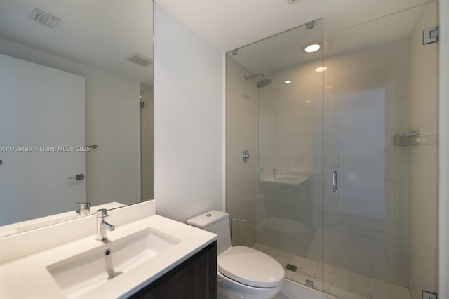 bathroom with vanity, toilet, and a shower with shower door