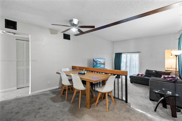 carpeted dining space featuring a ceiling fan, baseboards, visible vents, and a textured ceiling