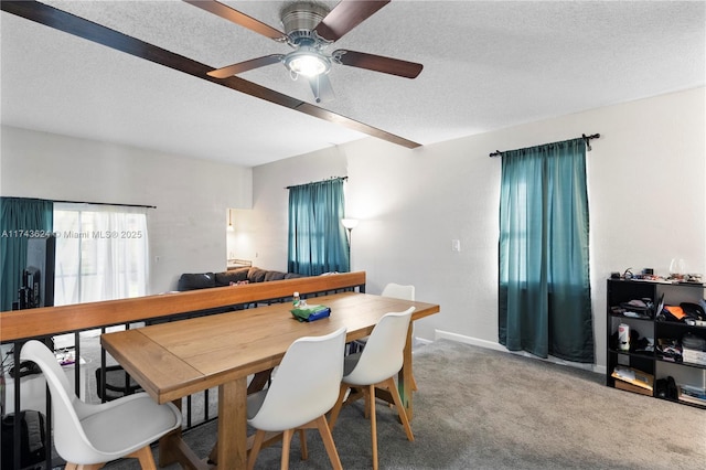 dining space featuring carpet floors, ceiling fan, baseboards, and a textured ceiling