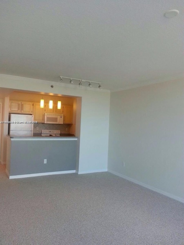 unfurnished living room featuring rail lighting, baseboards, light carpet, and crown molding