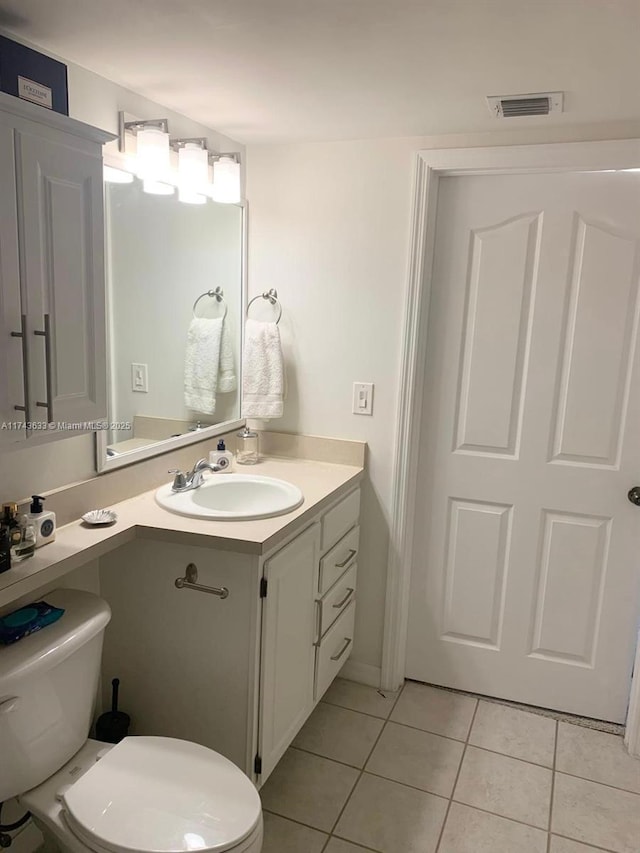 bathroom featuring tile patterned flooring, toilet, vanity, and visible vents