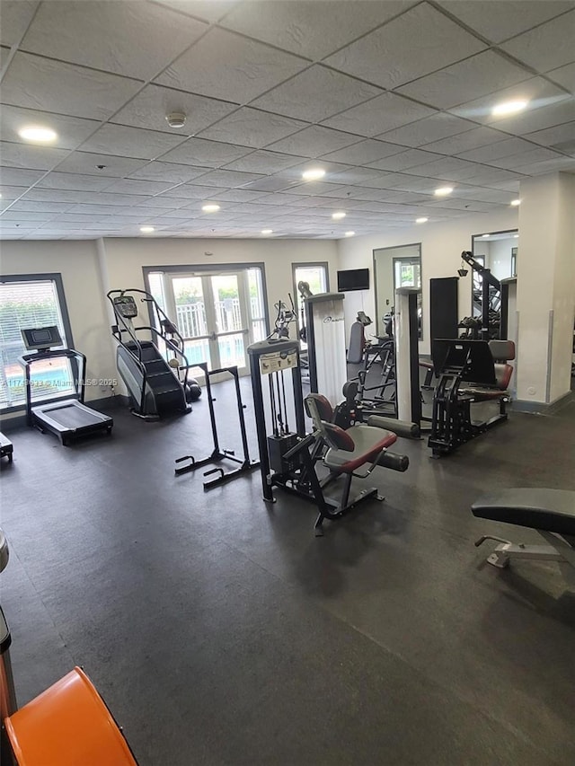 gym with a drop ceiling and a wealth of natural light