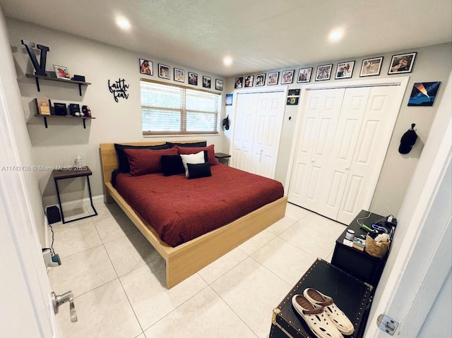 tiled bedroom featuring two closets