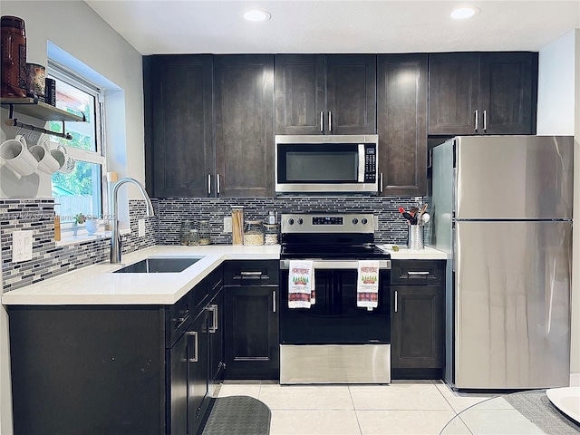 kitchen with light tile patterned flooring, appliances with stainless steel finishes, sink, and decorative backsplash