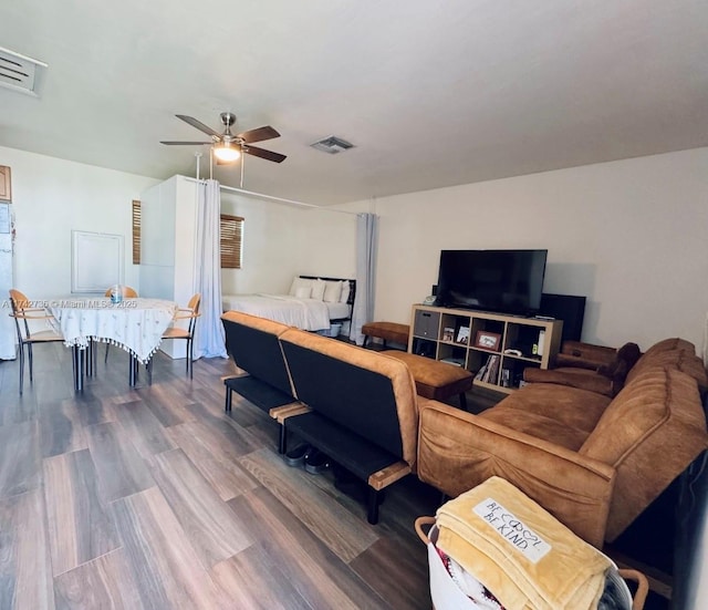 living room featuring wood-type flooring and ceiling fan