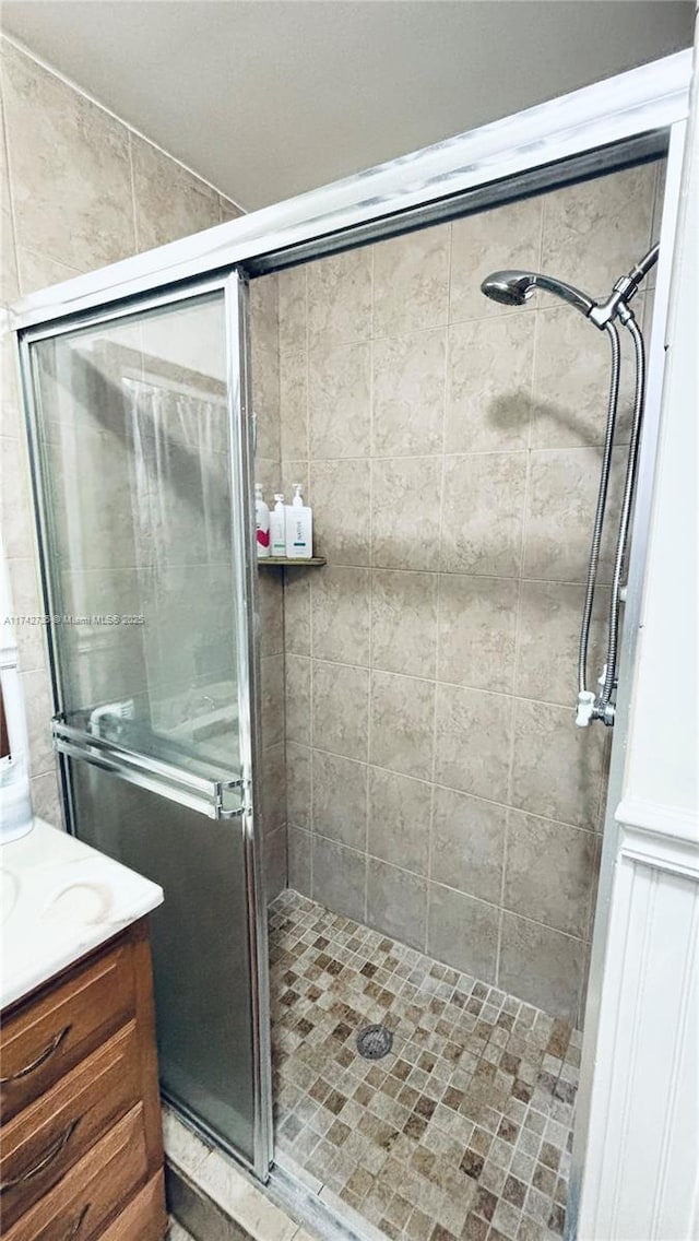 bathroom with a shower with door and vanity