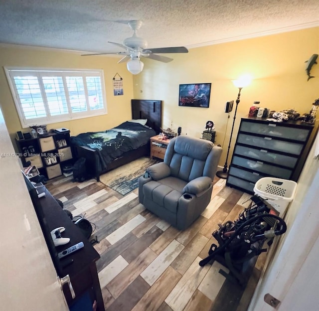 bedroom featuring hardwood / wood-style floors, ornamental molding, a textured ceiling, and ceiling fan