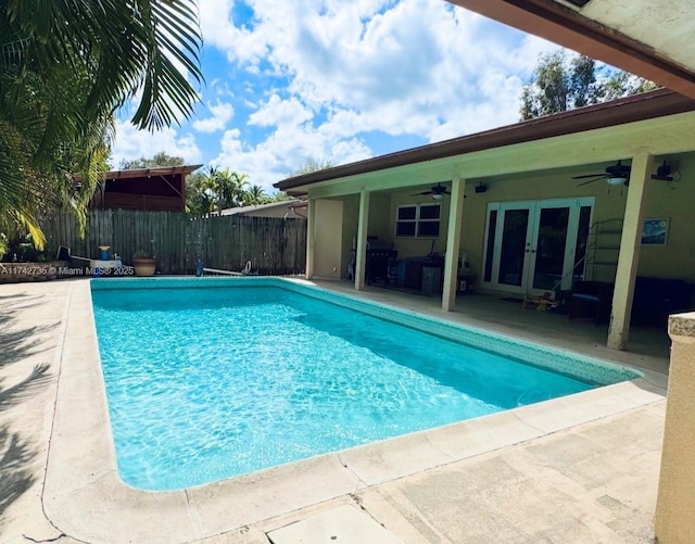 view of swimming pool featuring french doors, ceiling fan, and a patio area