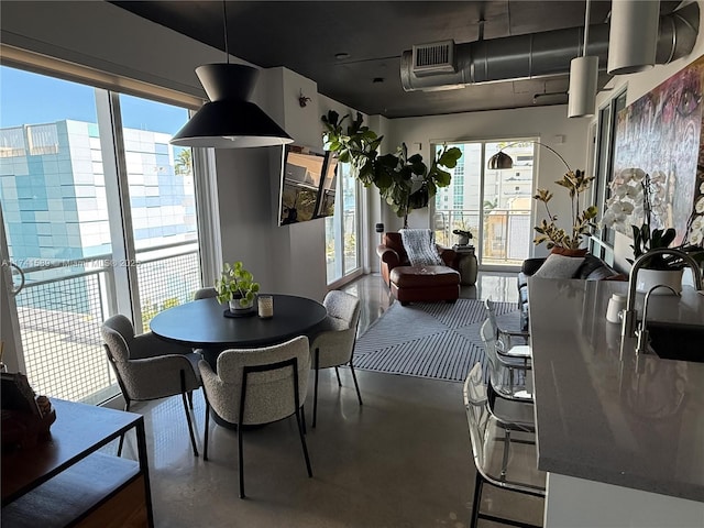 dining area featuring sink and concrete floors