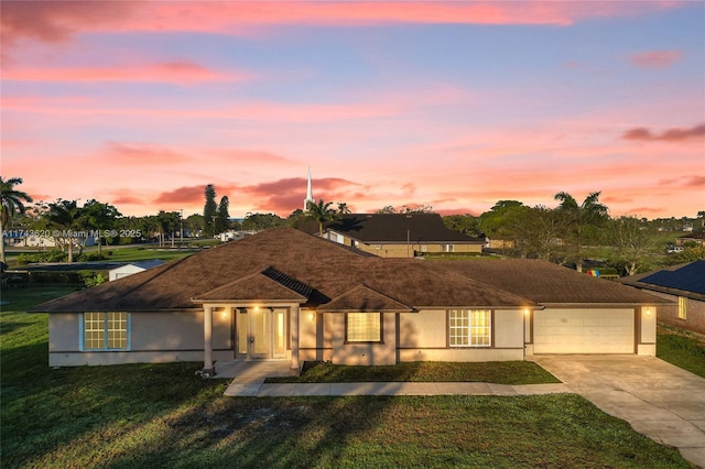 ranch-style home with a garage and a lawn