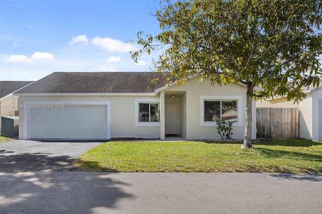 ranch-style home featuring aphalt driveway, stucco siding, an attached garage, a front yard, and fence