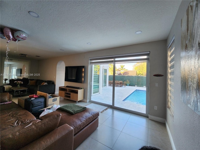 tiled living room featuring a textured ceiling