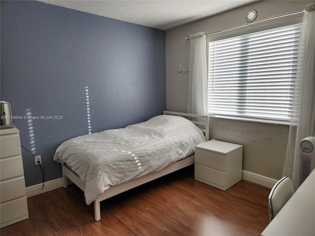 bedroom featuring dark wood-type flooring and a textured ceiling