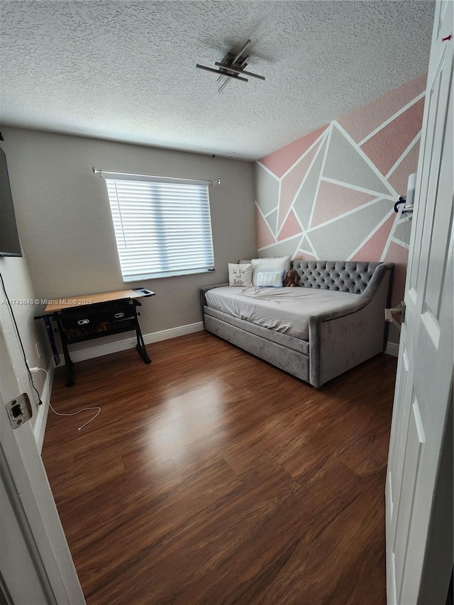 bedroom featuring dark hardwood / wood-style floors and a textured ceiling