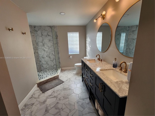 bathroom with tiled shower, vanity, and toilet