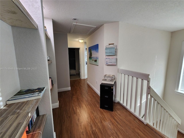 hallway with dark hardwood / wood-style floors and a textured ceiling