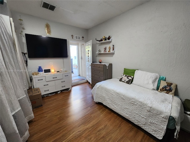 bedroom featuring dark hardwood / wood-style floors and access to outside