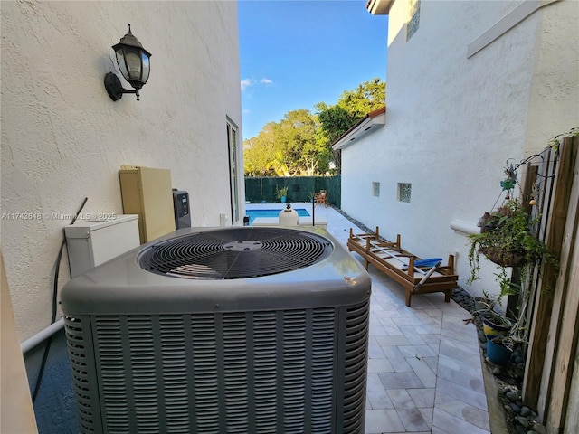 view of patio featuring a pool and central air condition unit