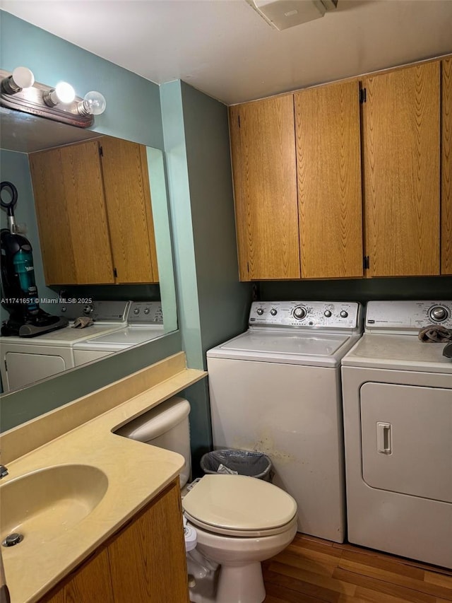 bathroom featuring vanity, hardwood / wood-style flooring, washer and dryer, and toilet