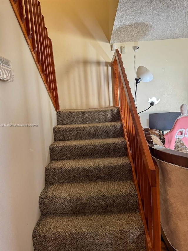 staircase with a textured ceiling