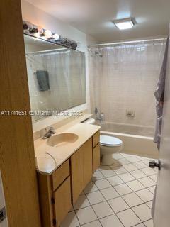 full bathroom with tile patterned flooring, vanity, shower / tub combo, and toilet