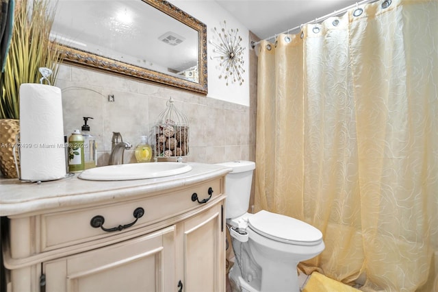 bathroom with tile walls, vanity, and toilet