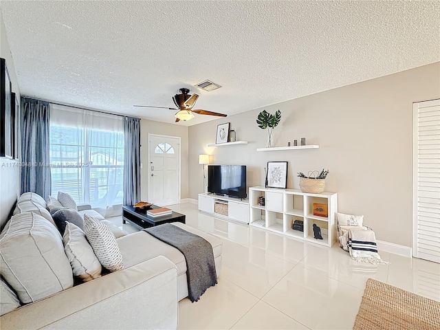 tiled living room with a textured ceiling, a ceiling fan, and plenty of natural light