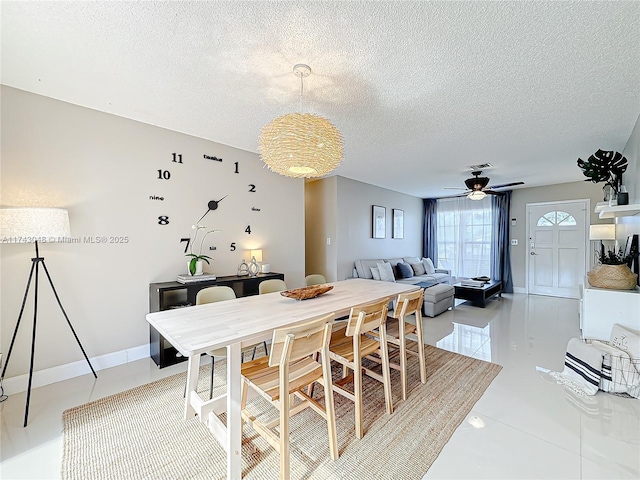 dining area featuring a textured ceiling, light tile patterned floors, a ceiling fan, and visible vents