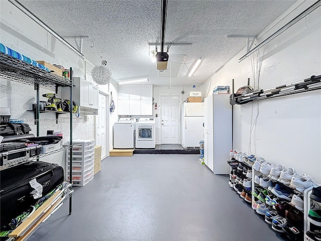 garage featuring freestanding refrigerator, washing machine and dryer, and a garage door opener