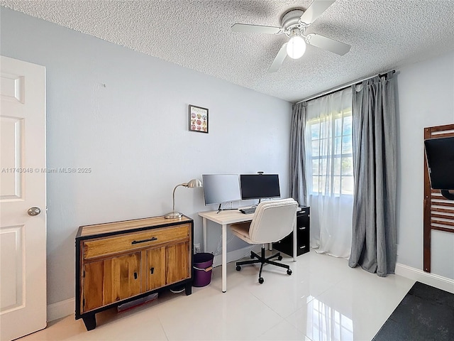 tiled office space with a textured ceiling, baseboards, and ceiling fan