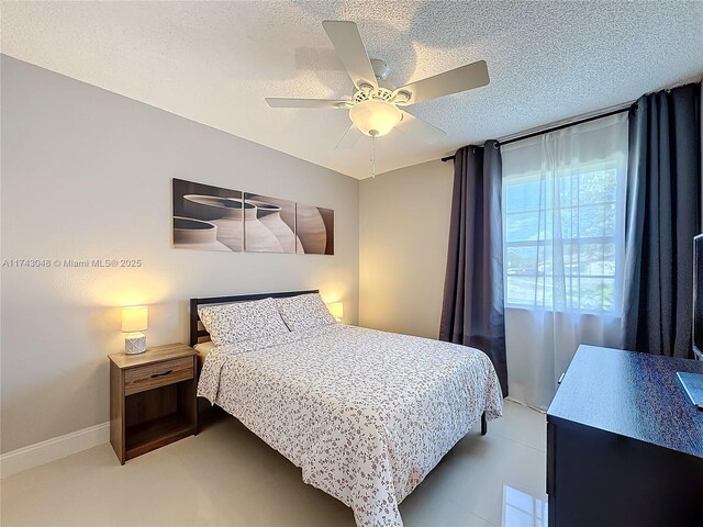 bedroom with ceiling fan, baseboards, and a textured ceiling